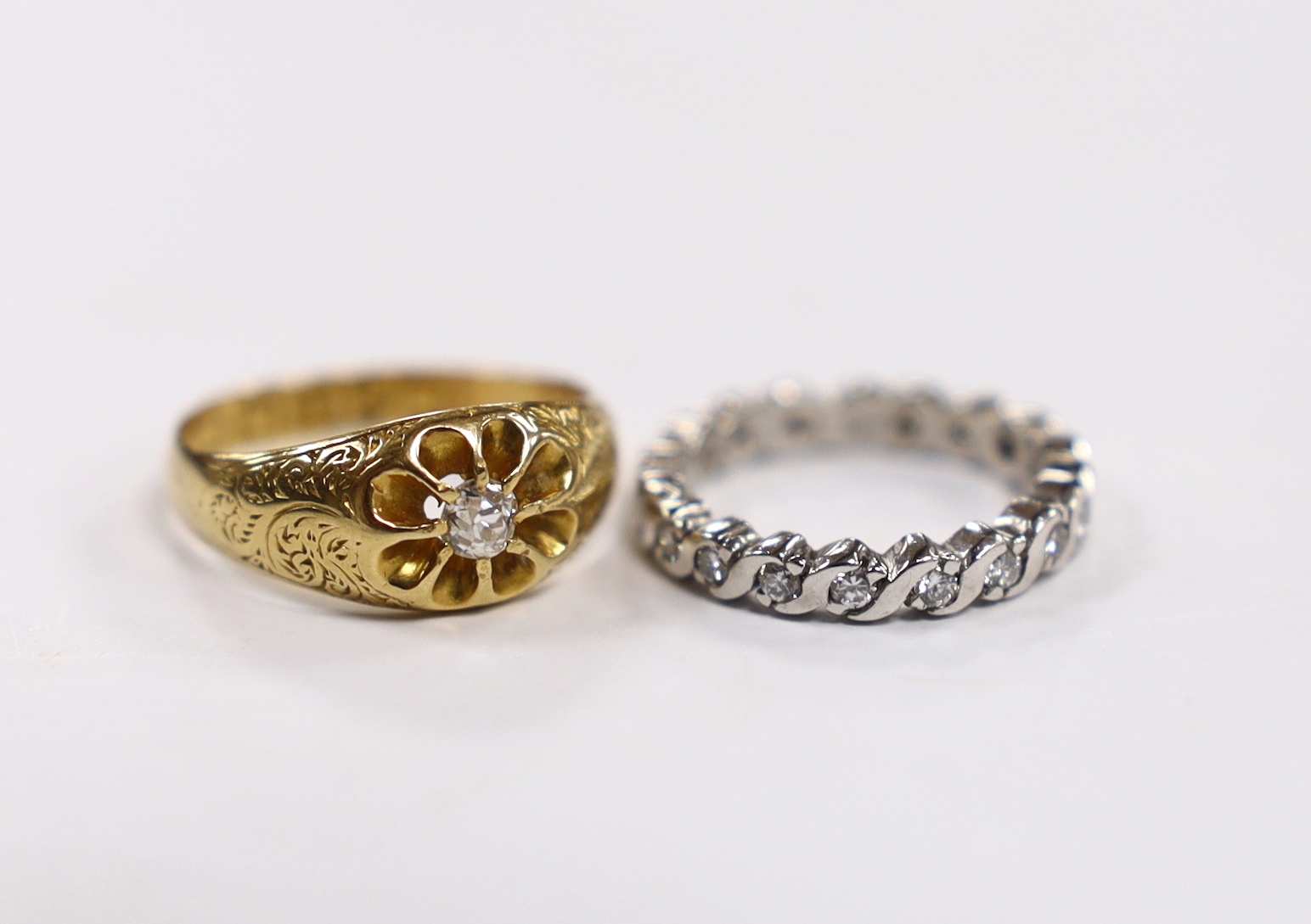 An early 20th century 18ct gold and claw set solitaire diamond ring, size M, gross 3.8 grams and a modern platinum and diamond chip set full eternity ring, size G, gross 3.1 grams.